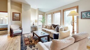 A living room with a sofa, armchair, coffee table, and a rug. - Peaceful Mountain View Home – Dog Friendly (Kalispell)
