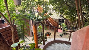 A wooden staircase surrounded by greenery, leading to a wooden deck.