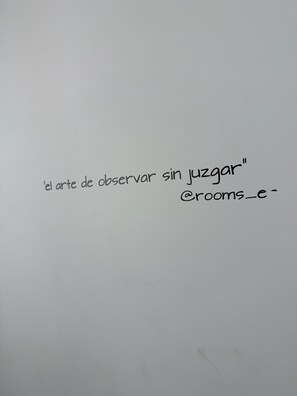 Eine weiße Wand mit spanischem Text und einem unvollständigen E-Mail-Adresse.
