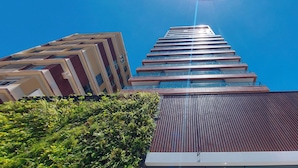 Un edificio moderno de gran altura con un cielo azul claro.
