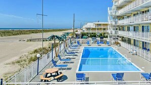 Un hotel con piscina, vista al mar y varios balcones.