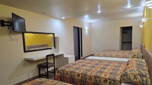 A hotel room with two beds, a desk, a chair, a TV, and a mirror. - Hotel Tamuín (Tamuín)