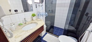 A bathroom with a white sink, mirror, and a glass shower enclosure.