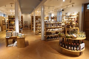 Un magasin bien éclairé, avec des étagères en bois remplies de divers produits, notamment des bouteilles et des bocaux.