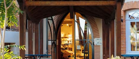 A building with a wooden roof structure, brick walls, and large arched windows.