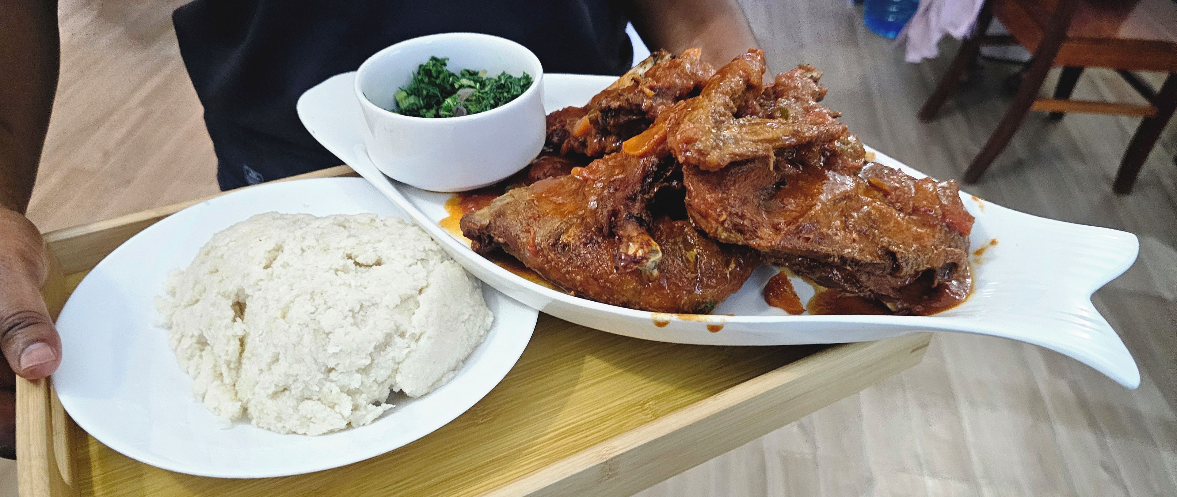 A tray with a plate of food including meat, a bowl of white rice, and a small bowl of greens.