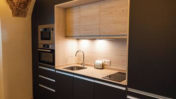 Apartamento superior, 1 cama de matrimonio con sofá cama, baño privado, vistas a la ciudad | Cocina privada | Frigorífico, microondas, horno y placa de cocina