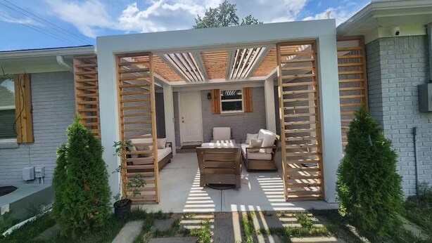 Un espacio exterior moderno con un pérgola de madera, un sofá y una mesa de comedor.