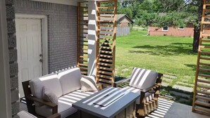 Un patio al aire libre con una pérgola de madera, un sofá y una mesa.