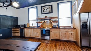 Une cuisine moderne avec des meubles en bois, des appareils électroménagers en acier inoxydable et une grande fenêtre.