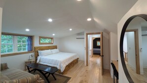 Une chambre à coucher avec un lit, un bureau, une chaise, une fenêtre et un miroir.