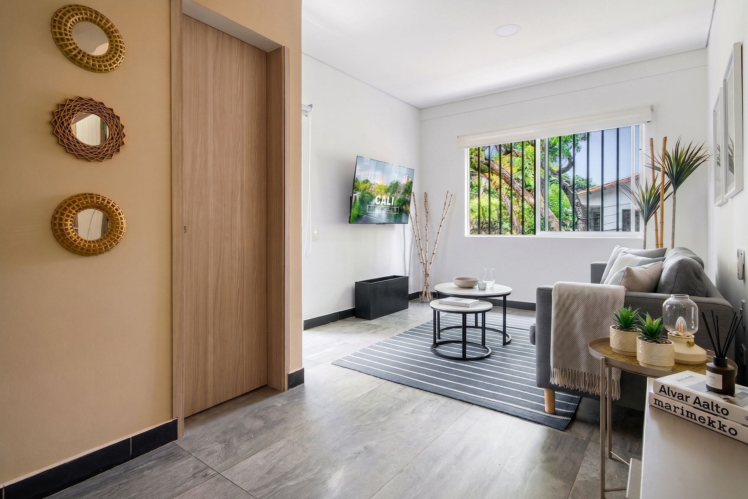 Una sala de estar moderna con un sofá, una mesa de centro y un televisor montado en la pared.