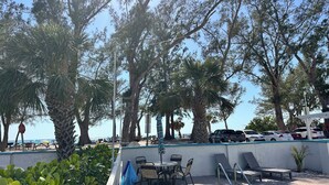 A poolside area with lounge chairs, a table, and a stop sign. - Alamanda Villas (Holmes Beach)