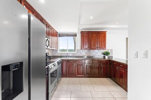 Una cocina moderna con electrodomésticos de acero inoxidable, armarios de madera y un amplio ventanal con vistas.