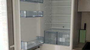 A kitchen with a built-in refrigerator, a sink, and a countertop. - KomfortPlus New Construction - Apartment with a sunny balcony and free parking (Bad Zwischenahn)