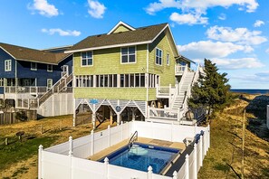 Une grande maison avec une piscine, une terrasse et un escalier menant à un deuxième étage.