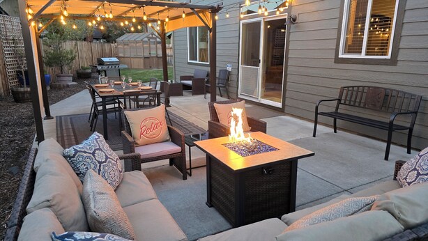 An outdoor patio with seating, a fire feature, and string lights. - 2 min to Downtown Sisters, Family Friendly, XBOX, Game Rm, Outdoor Patio w/ BBQ, (Sisters)