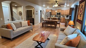 A spacious living room with a sofa, coffee table, and a dining area with a table and chairs. - 2 min to Downtown Sisters, Family Friendly, XBOX, Game Rm, Outdoor Patio w/ BBQ, (Sisters)