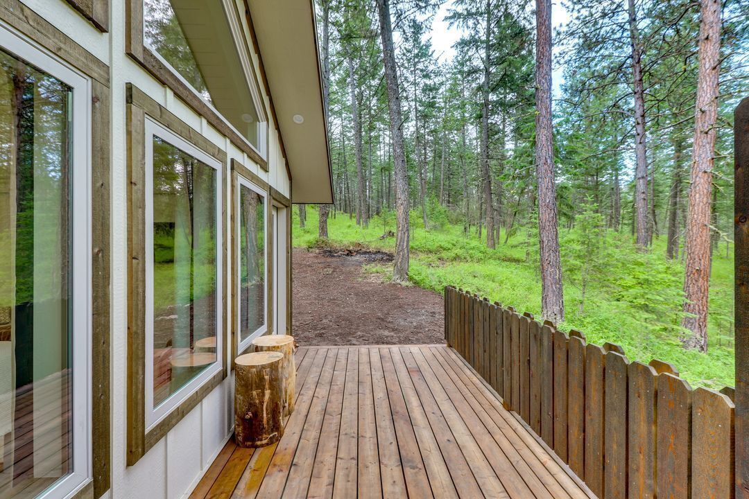 Une terrasse en bois avec vue sur une forêt.