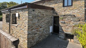 Ein Steinhaus mit kleinem Eingang und einem Schild, auf dem "Norvys" steht.