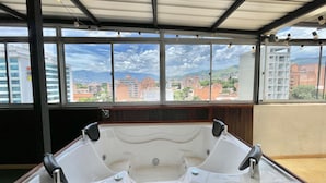 A large, empty hot tub in a room with large windows offering a city view. - Edificio RG33 (Medellín)