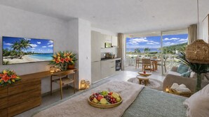 A modern hotel room with a balcony, a dining area, and a kitchen. - Anse Marcel Cove Suites St. Martin (Anse Marcel)