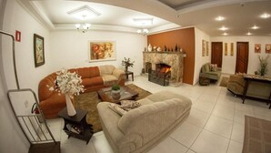 Un salon spacieux avec une cheminée, un canapé, une table basse et un coin repas.