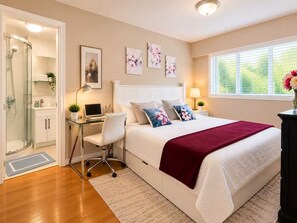 Ein Schlafzimmer mit Bett, Schreibtisch, Stuhl und einer Dusche.