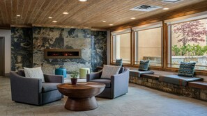 A modern lounge area with two sofas, a coffee table, and a fireplace.