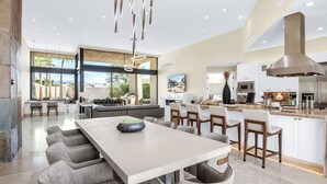 Une cuisine spacieuse dotée d’un grand îlot central, d’appareils électroménagers modernes et bénéficiant d’un éclairage naturel abondant.