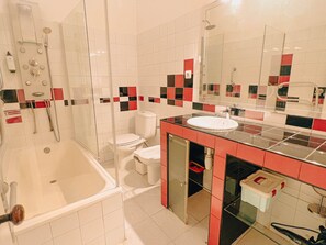A bathroom with a bathtub, toilet, and sink.