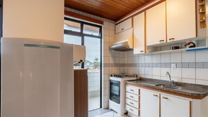 Una cocina moderna con armarios blancos, horno empotrado y encimera de granito.