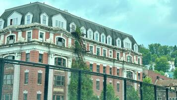 En stor, historisk bygning med flere etager, med en markant murstensfacade og et symmetrisk design.