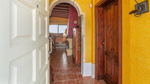 A hallway with a white door, a wooden door, and a yellow wall.
