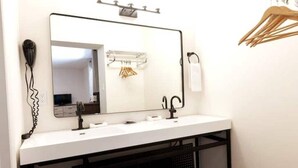 A bathroom with a white vanity, a large mirror, a black sink, and a towel rack. - Double Queen Bedroom_Western Themed_Bryce Canyon (Panguitch)