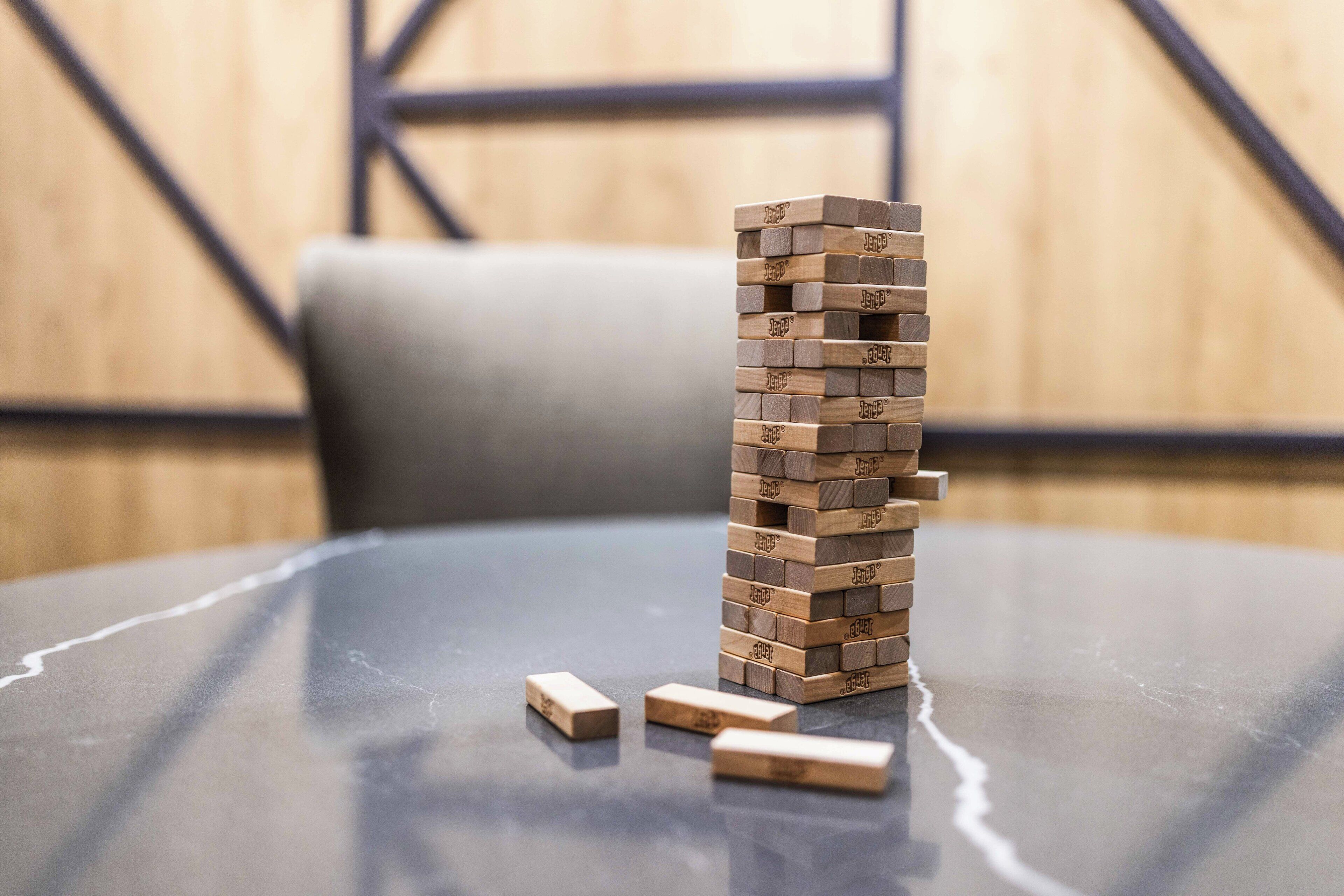 A stack of wooden blocks on a reflective surface with a blurred background.