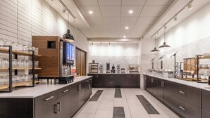 Una cocina moderna con armarios oscuros, una isla central y suelo de baldosas.