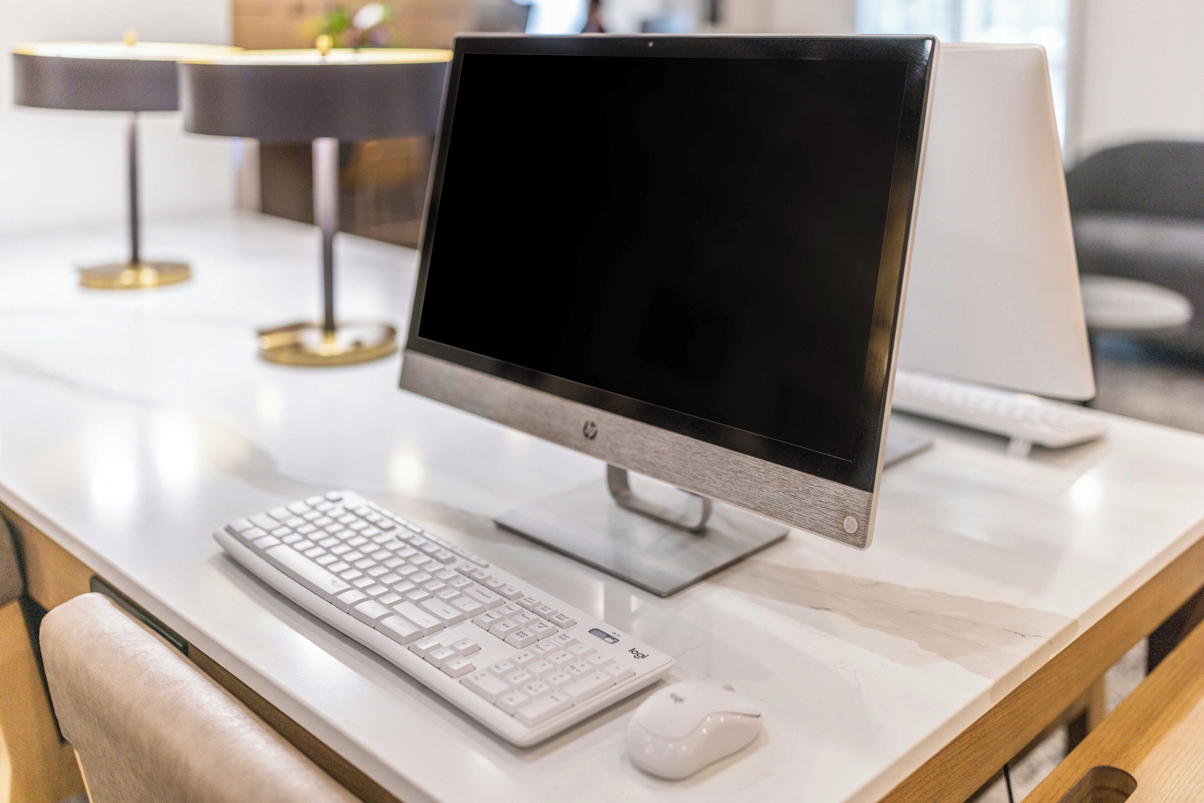 A modern office desk with a desktop computer, keyboard, and mouse.