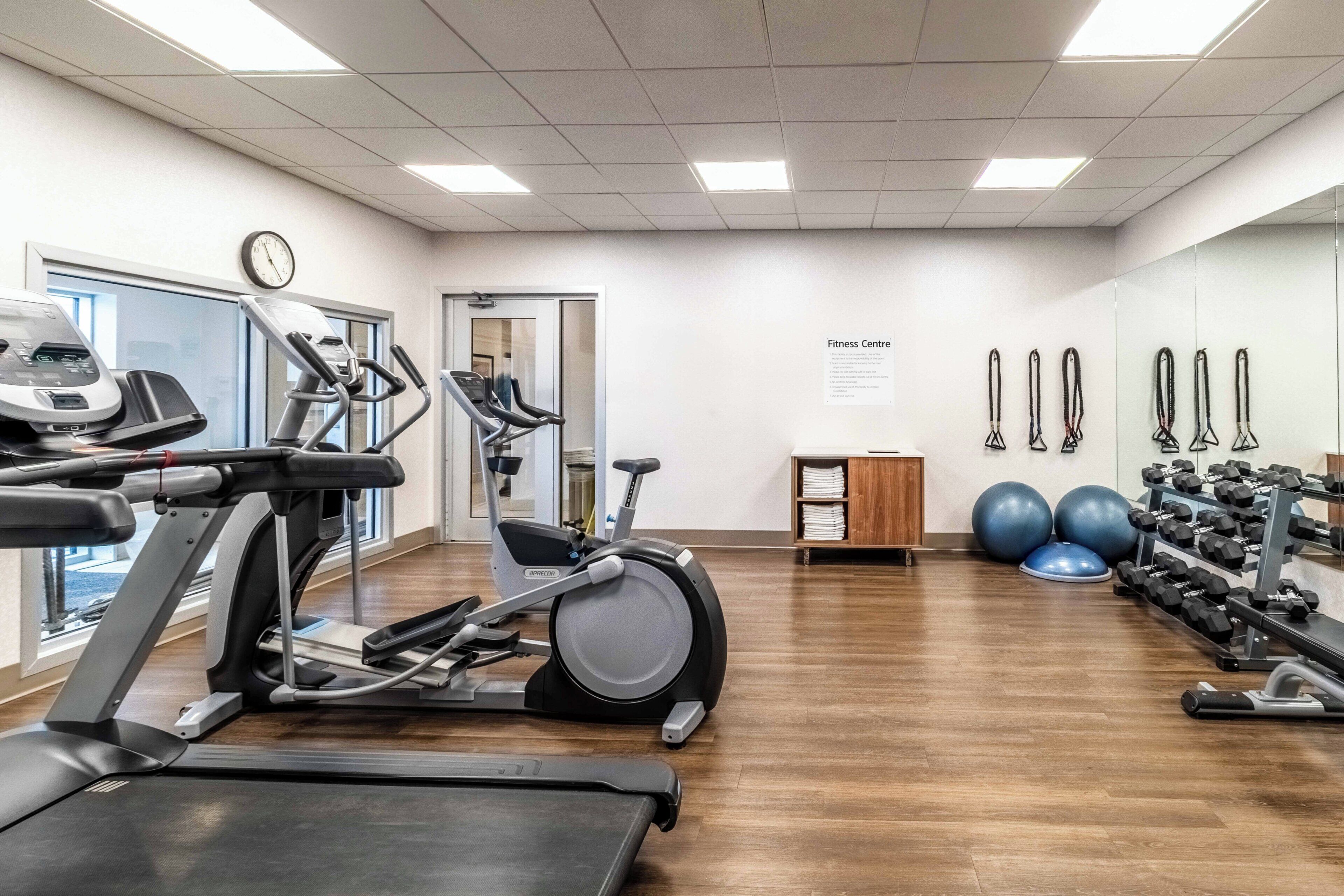 A fitness center with treadmills, elliptical machines, and free weights.