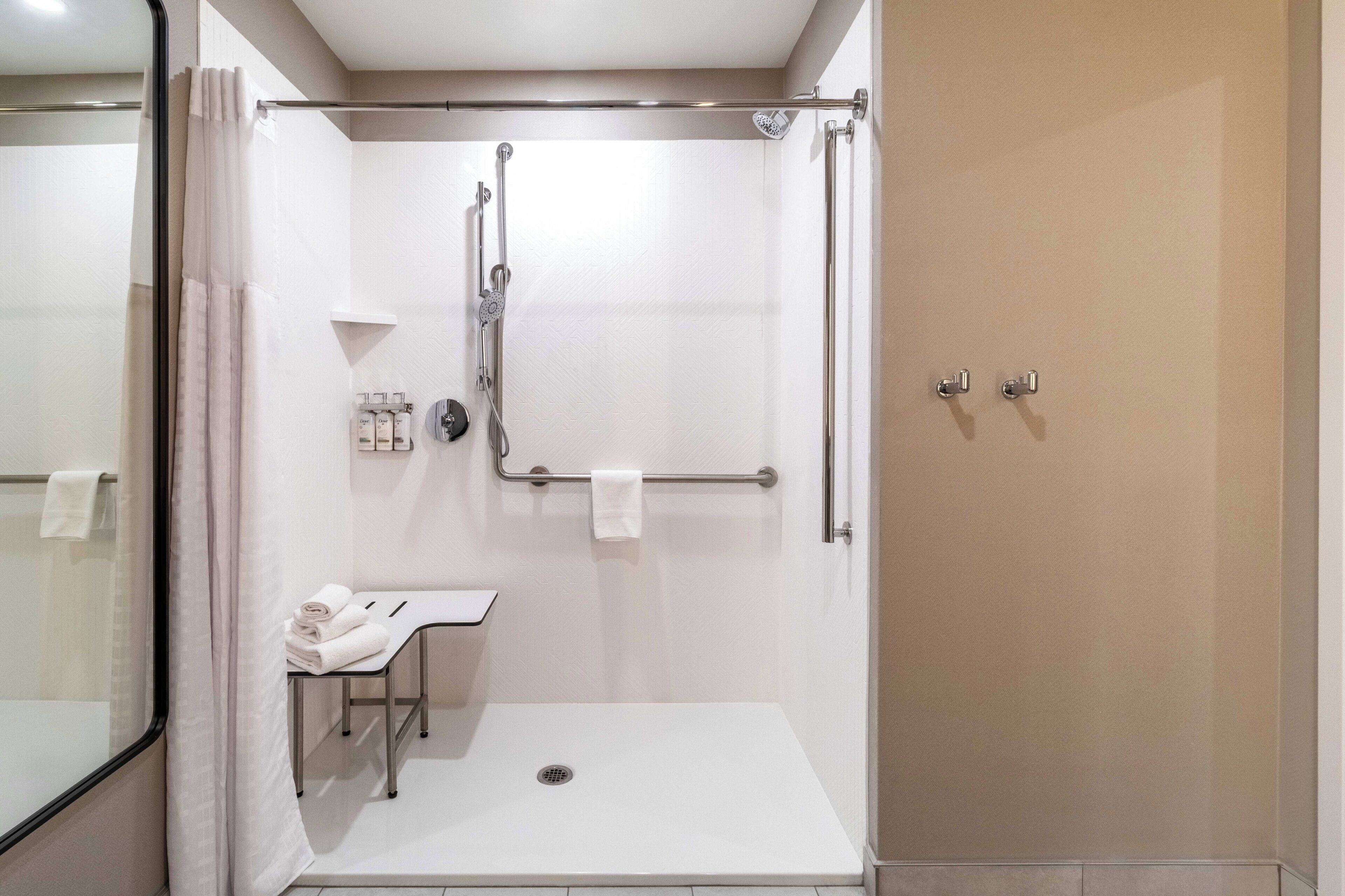 A modern bathroom with a walk-in shower, a toilet, and a sink.