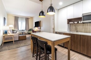 A modern hotel room with a dining area, kitchenette, and a living space with a sofa and a TV. - Staybridge Suites Halifax Dartmouth by IHG (Halifax)