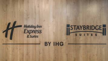 A wooden wall with logos for Holiday Inn Express & Suites and Staybridge Suites by IHG.
