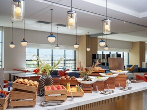 A modern kitchen with a long counter, wooden crates of fruits, and a variety of food items. - Holiday Inn Express Aksu by IHG (Aksu)
