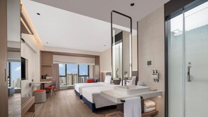 A modern hotel room with a large bed, a separate sitting area, a large bathroom with a mirror, and a view of the city. - Holiday Inn Express Aksu by IHG (Aksu)
