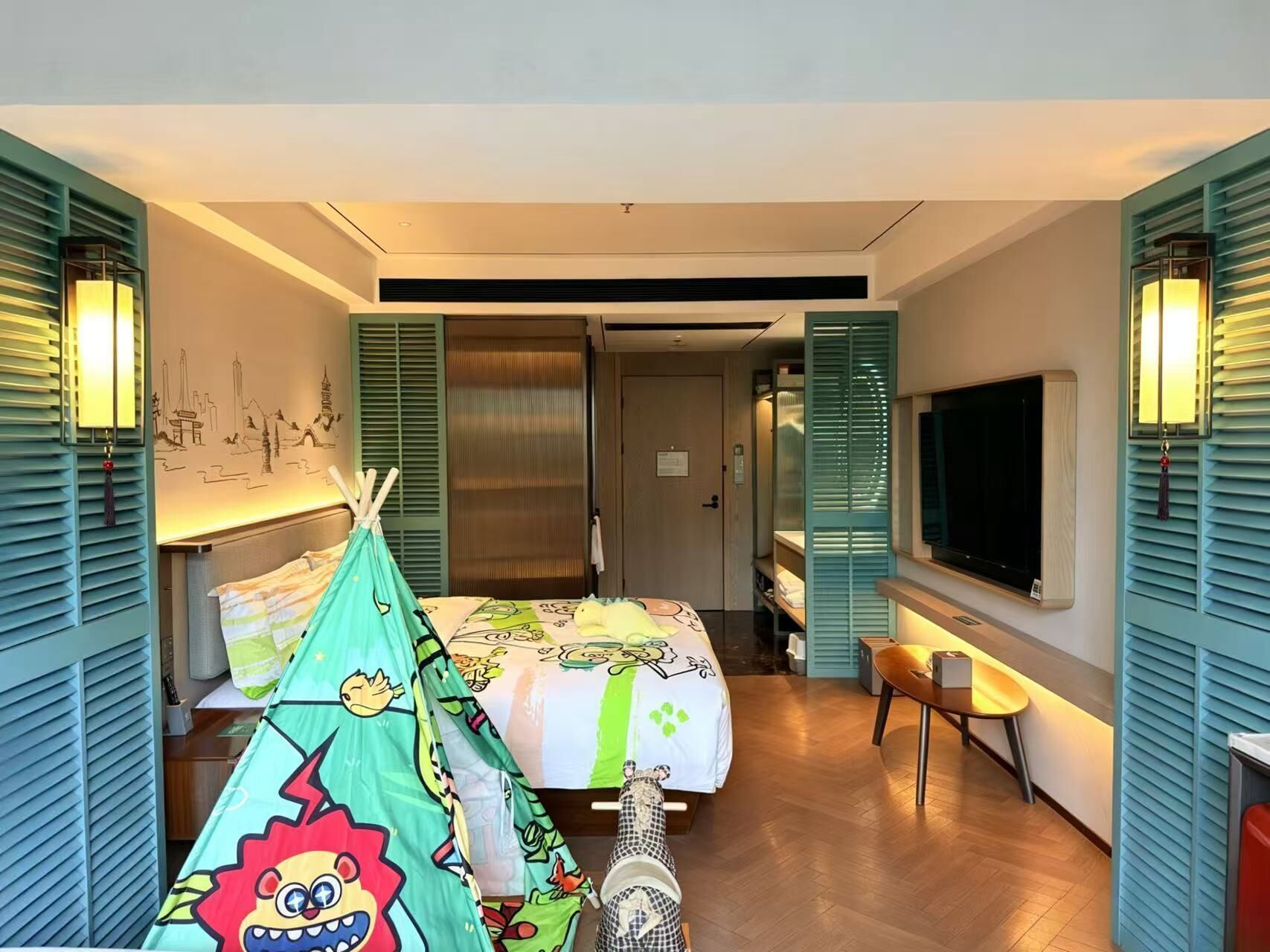 Ein Hotelzimmer mit Bett, Fernseher, Schreibtisch und Stuhl.
