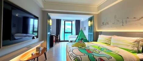 Ein Hotelzimmer mit Bett, Wandfernseher, kleinem Tisch und Fenster.