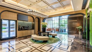 Un vestíbulo moderno con una zona de estar central, un bar y un amplio ventanal con vistas al exterior.