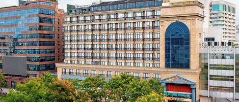 Ein mehrgeschossiges Hotel mit großem Eingangsbereich, zahlreichen Fenstern und einer markanten Bogenöffnung.