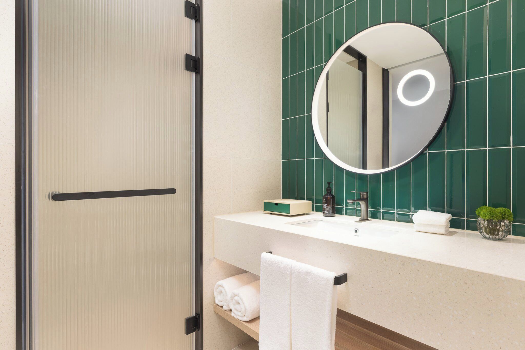 A bathroom with a mirror, sink, and towel rack.