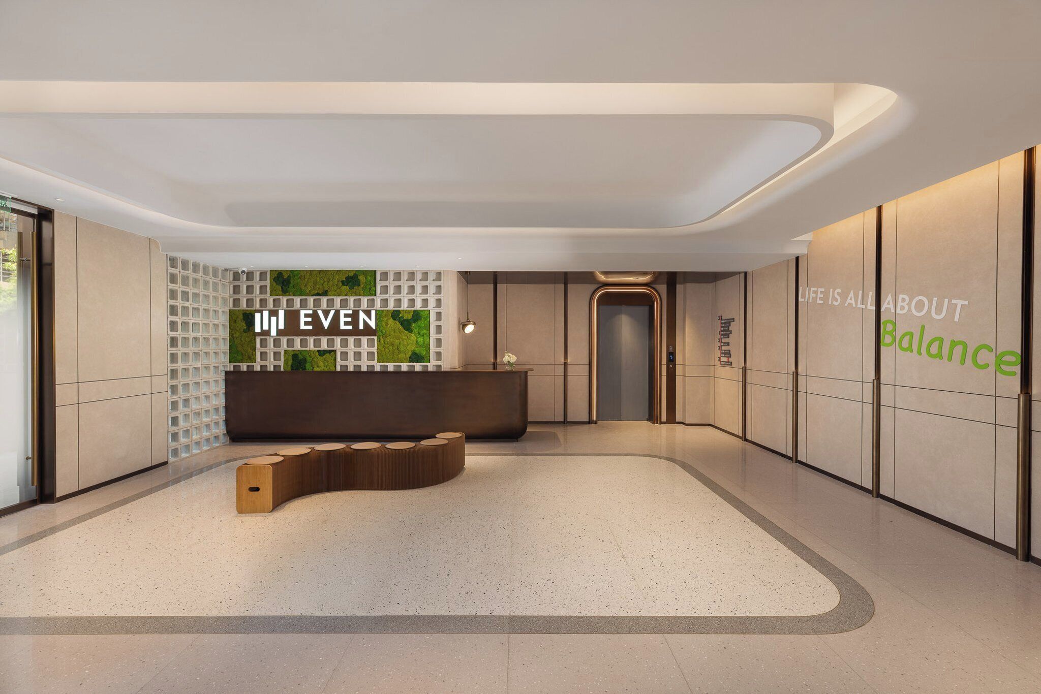 A modern reception area with a reception desk, a seating area, and a wall with a green accent.